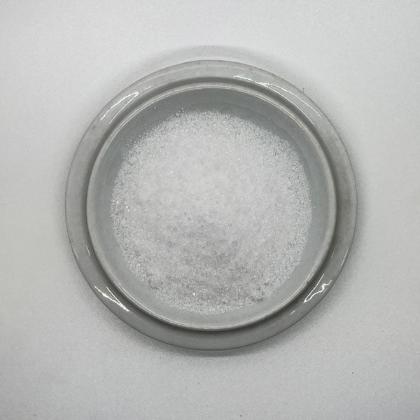 white powder on a round off-white ceramic tray