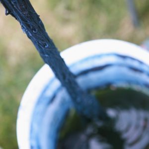 blue yarn over an indigo vat in a white bucket