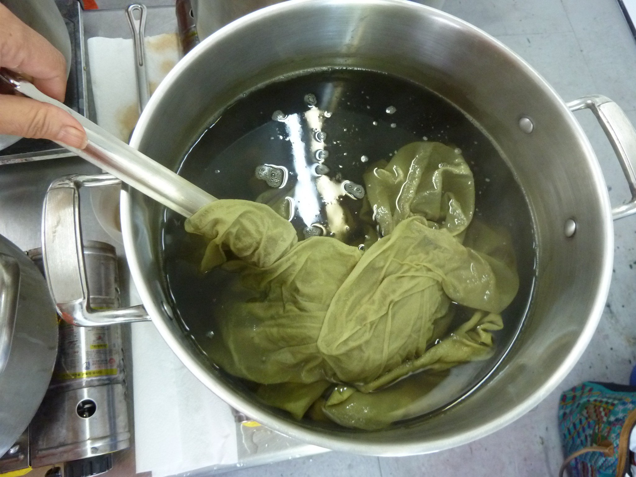 yellow fabric in a stainless steel dyepot