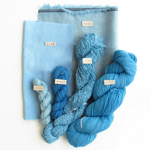 Skeins of yarn and fabric dyed with Saxon blue