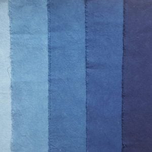 Seven swatches of blue fabric from very pale on the left to dark navy blue on the right