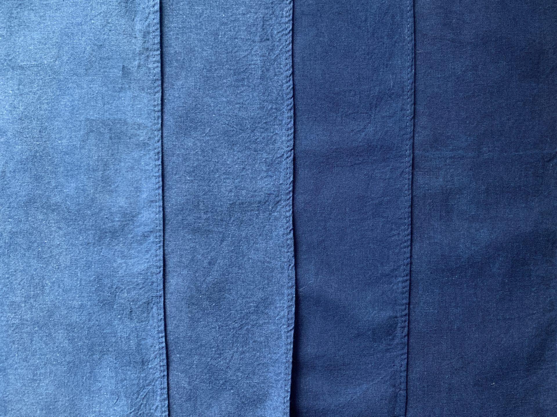 Four strips of cotton in varying shades of blue, from lightest on the left to darkest on the right