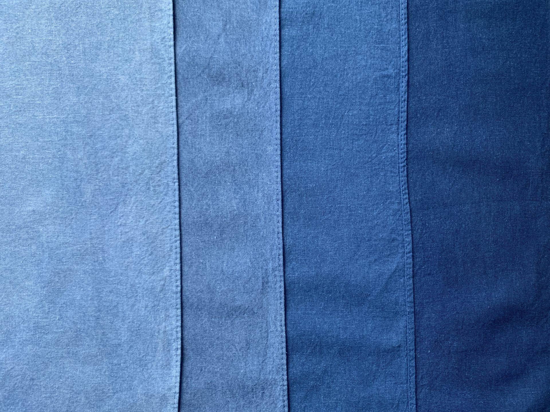 Four strips of cotton in varying shades of blue, from lightest on the left to darkest on the right