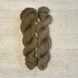 Two skeins of green-gray yarn on a cream background