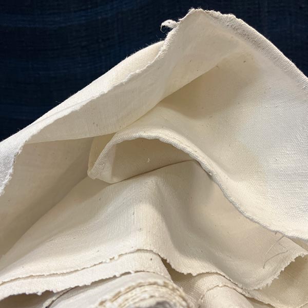 undyed fabric draped in a loose pile