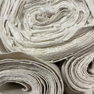 rolls of undyed fabric stacked on top of one another