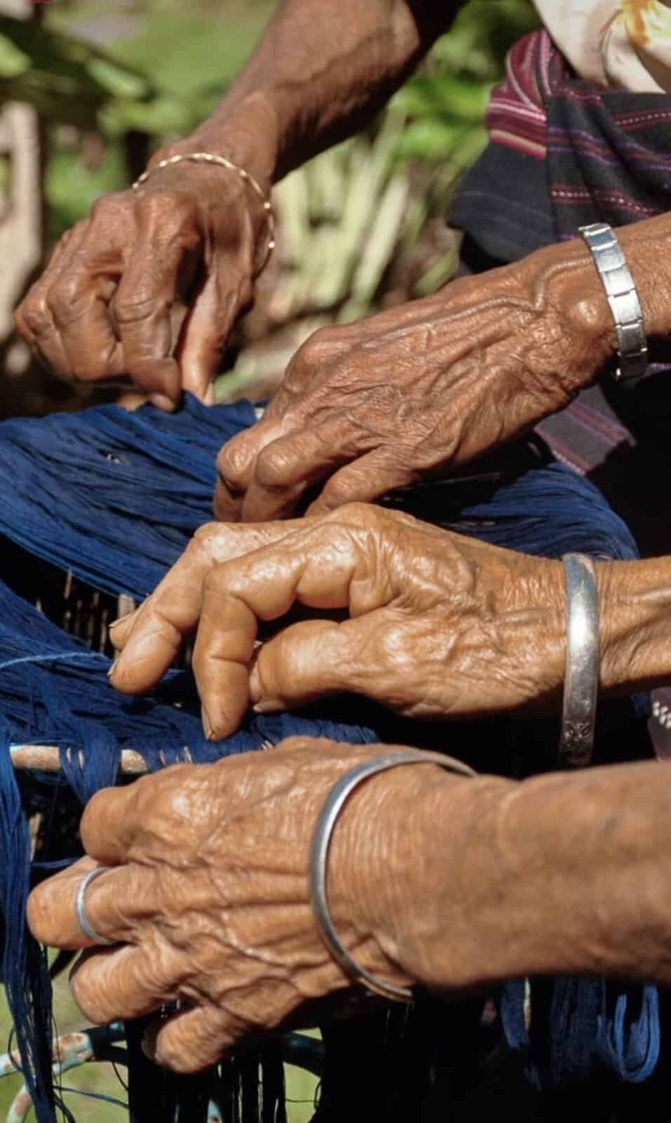 Weavers' hands working indigo-dyed yarn